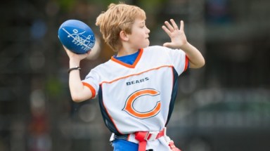 kid in jersey throwing a football