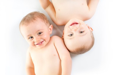 Twin brother having fun on a studio white floor