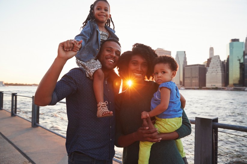 Young family with daughters standing on quayside