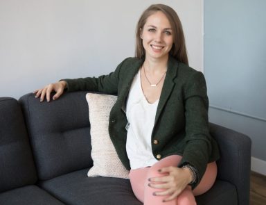 woman in preppy outfot sitting on couch