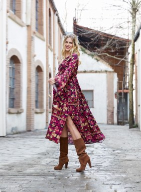 pregnant model in boho chic magenta dress and brown slouchy boots on a cobbletone street