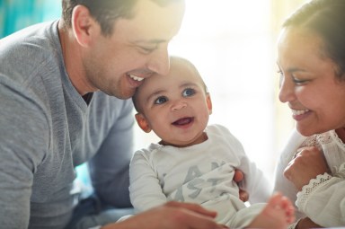 Shot of an adorable baby boy bonding with his father and father at home