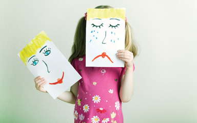 girl holding a picture of sad face