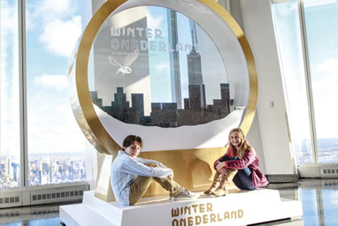 children in front of giant snowglobe