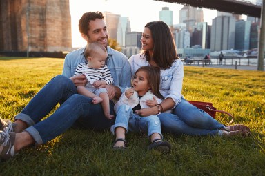 parents with little kids in the city sitting outside in the sun