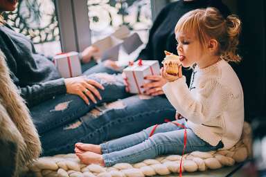 girl-eating-cupcake-while-sitting-beside-woman-in-blue-denim-1261408