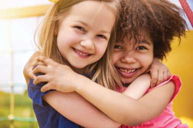 two young girls hugging each other