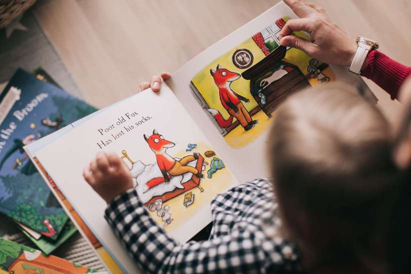 child reading book with parent