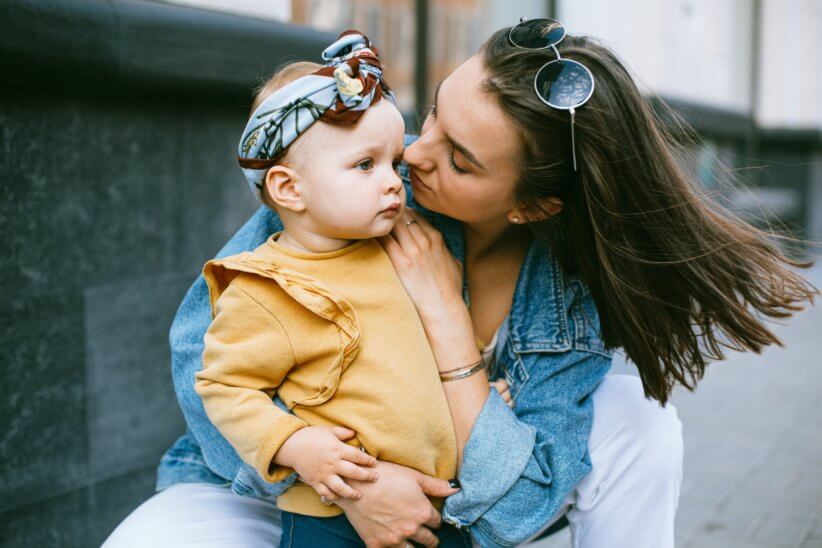 woman holding child and looking at their face, feminist raising a child