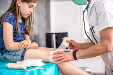 Medical doctor bandaging patient