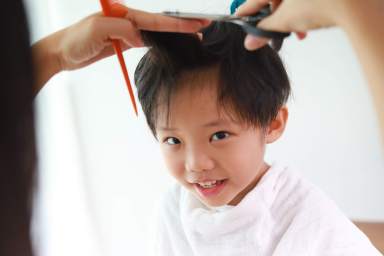 Mother giving son haircut