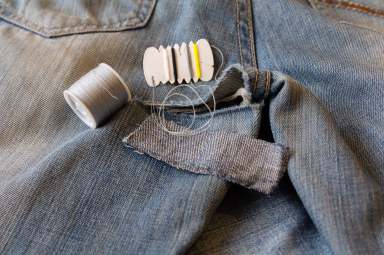 Sewing needles and thread, embroidered on the äæèíñîâûõ pants. Repair of defects