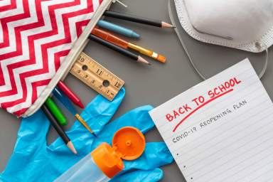 Back to school COVID-19 reopening plan, flat lay arrangement of school supplies and personal protective equipment