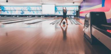 Kid releasing ball in bowling alley