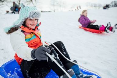 girl sledding down a hill