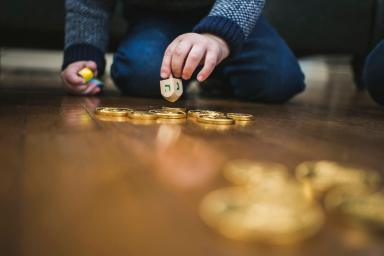 Boy playing dreidl game during Hanukkah