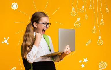 Modern education of children. Overjoyed school girl with backpack is happy with test result, holds laptop