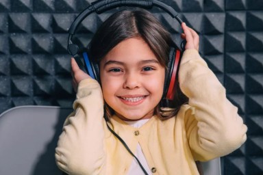 Cute little mixed race child while procedure hearing exam. Girl wearing special headphones getting hearing test, audiometry