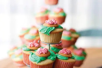 vanilla cupcakes with green and pink frosting, topped with vanilla wafers