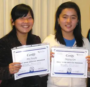 Students Mia Nonaka from Japan and Minjung Kim from Korea hold up their ESL certificates