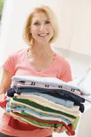 woman holding laundry; clothing drive; mom with laundry