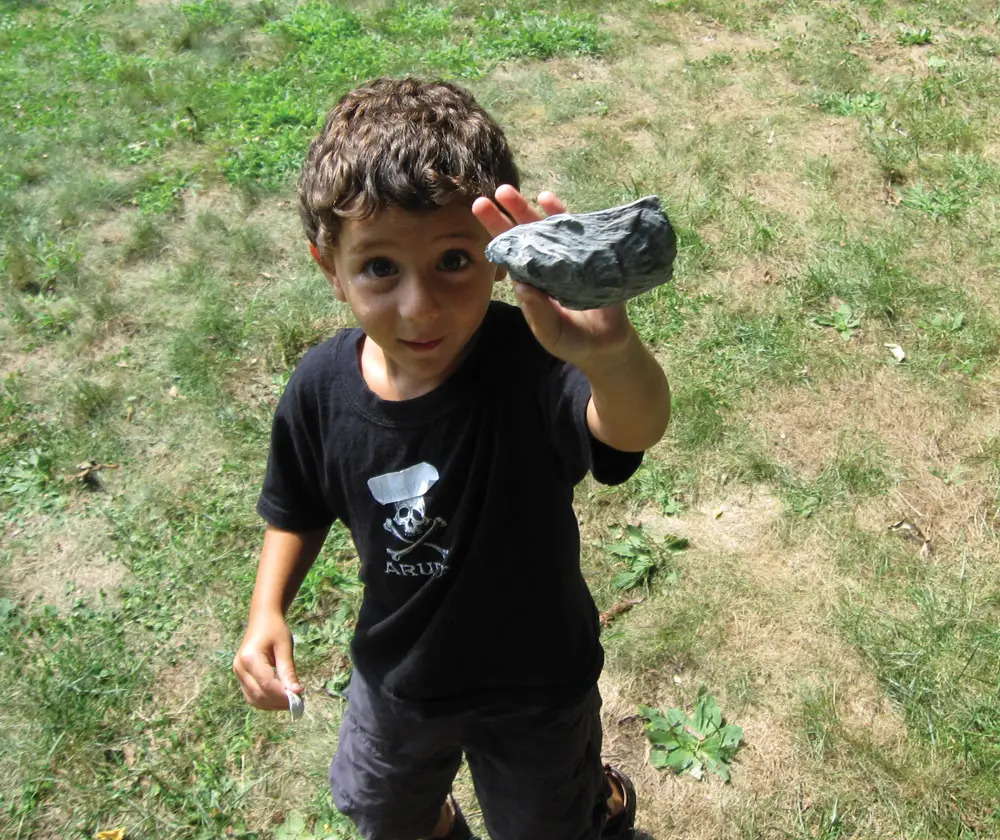 young boy holding a rock on earth day