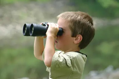 child with binoculars; boy bird watching