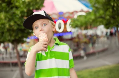 Cute boy enjoying ice cream during summer carnival
