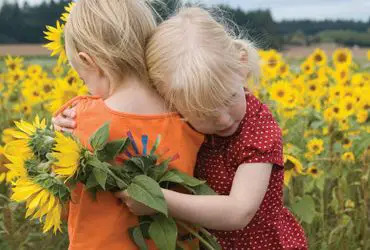 girls-hugging-in-flower-field