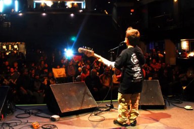 kid-playing-guitar-on-stage