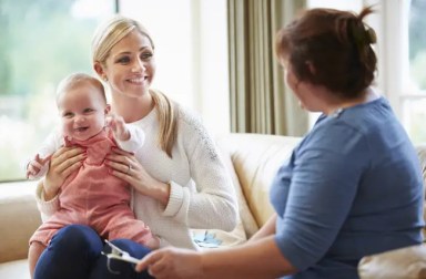 parent-holding-child-talking-to-nanny