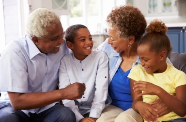 Grandparents,And,Their,Young,Grandchildren,Relaxing,At,Home