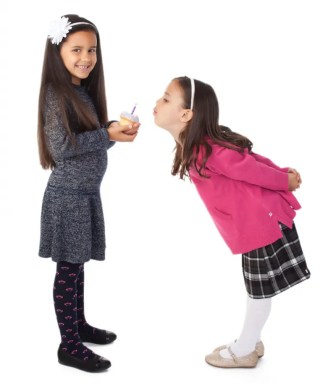 sisters-blowing-out-cupcake