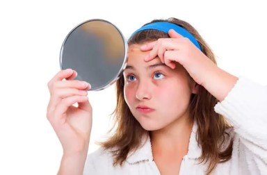 teen-looking-at-pimple-in-mirror