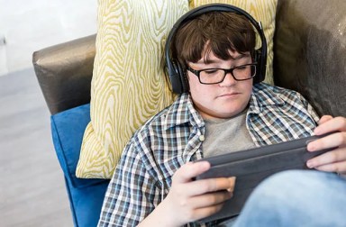 teenage-boy-with-headphones-using-tablet