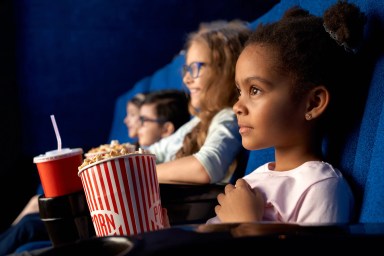 African girl with friends in cinema.