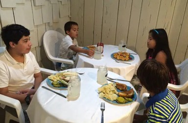 young-children-sitting-with-meal-using-manners