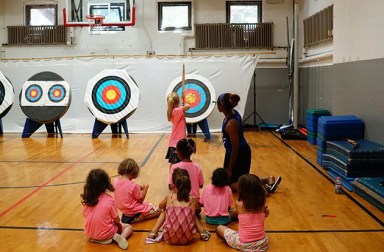 young-girls-practicing-archery-at-camp