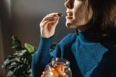 Cbd cannabis gummy – Woman eating edible weed sweet candy leaf for anxiety alternative treatment – Medical marijuana