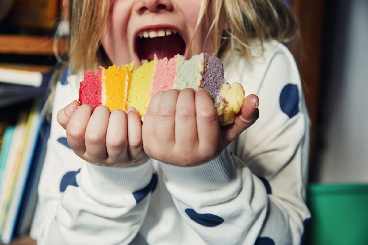 Child holding a piece of birthday cake