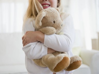 Young girl hugging teddy bear